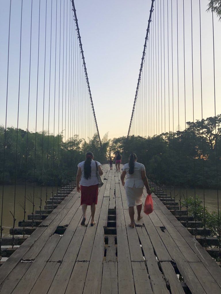 Women in Colombia walk across a bridge together