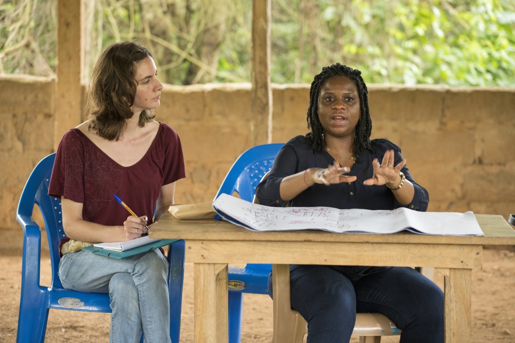 female student sitting next to a woman speaking