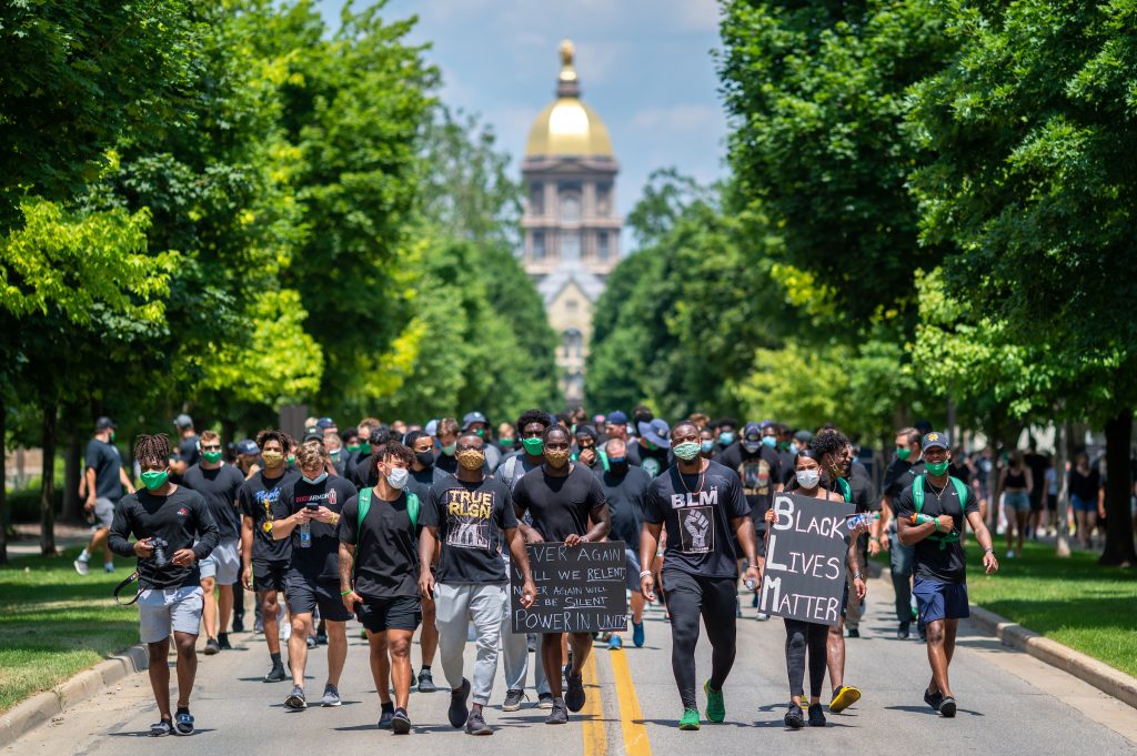 Members of the Notre Dame football team lead participants on a walk through campus in recognition of Juneteenth.