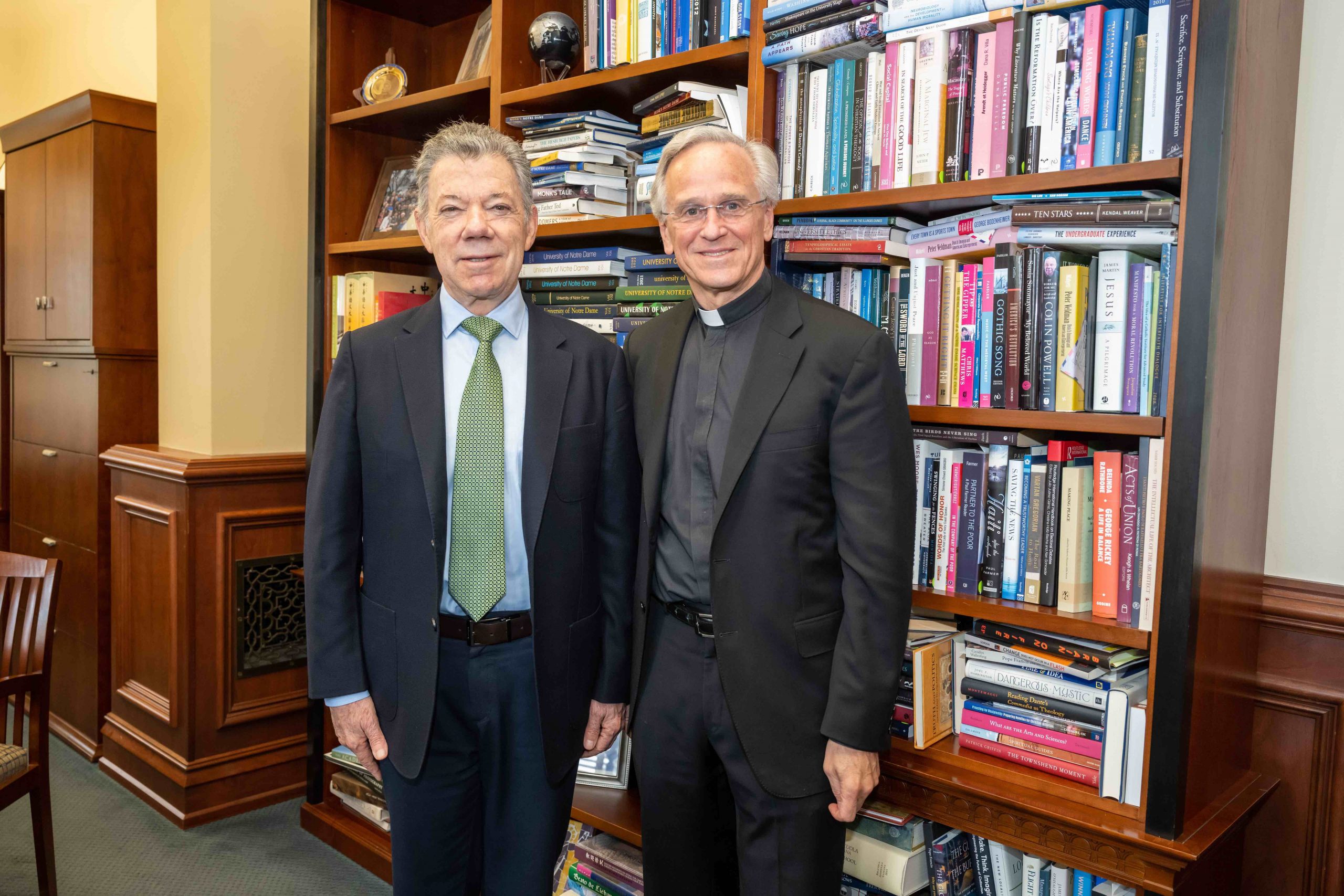 President Juan Manuel Santos standing next to Fr. John Jenkins in front of a bookshelf