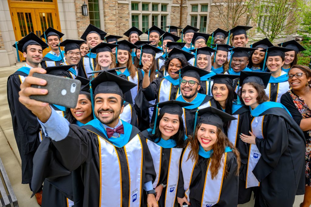 photo of group of students in graduation caps and gowns taking a selfie