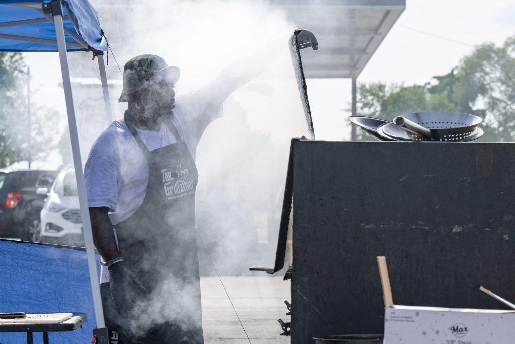 Raymond Barbour, owner of Ko's Port-a-Pit Barbecue, prepares smoked ribs under a tent at AutoZone on Western Avenue in South Bend. Barbour went through the South Bend Entrepreneurship and Adversity Program.